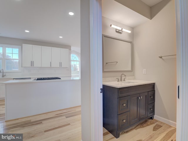 bathroom with vanity, hardwood / wood-style flooring, and a healthy amount of sunlight