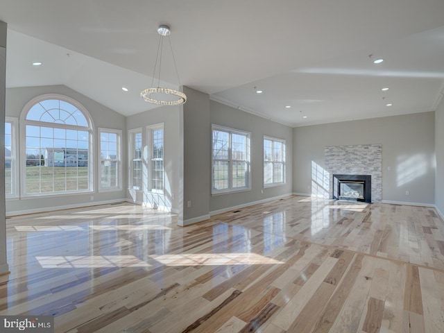 unfurnished living room featuring a fireplace, ornamental molding, lofted ceiling, and light hardwood / wood-style flooring