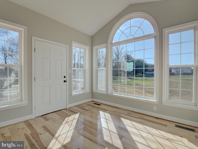 unfurnished sunroom featuring a wealth of natural light and lofted ceiling