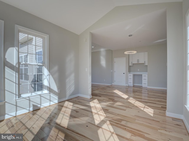 unfurnished living room featuring lofted ceiling and light wood-type flooring