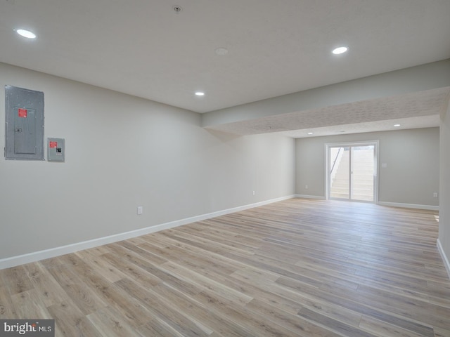 interior space with electric panel and light hardwood / wood-style flooring