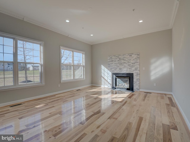 unfurnished living room featuring crown molding, a fireplace, and light hardwood / wood-style flooring