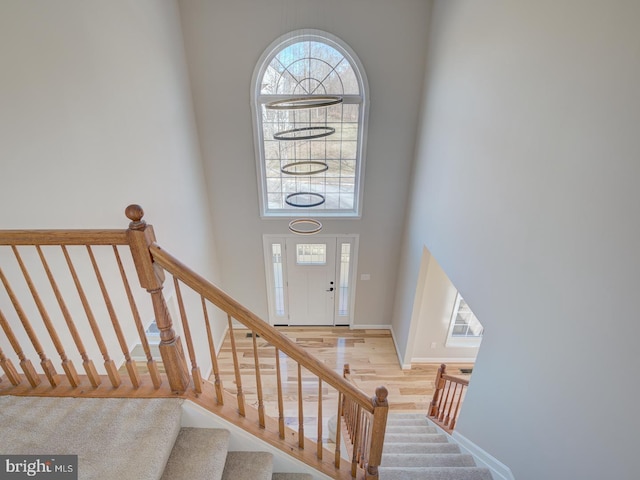 stairs with a high ceiling and wood-type flooring