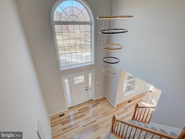 foyer entrance featuring a high ceiling and light wood-type flooring