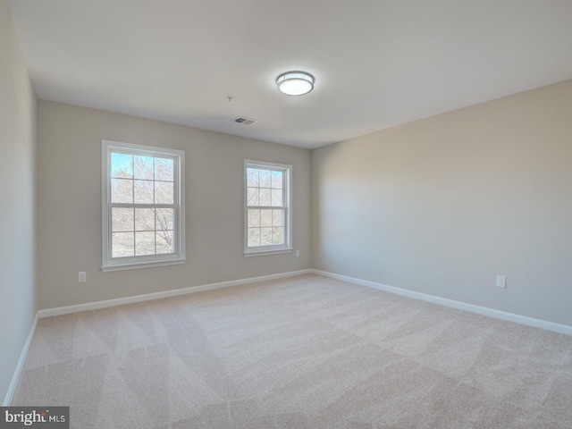 spare room featuring light colored carpet