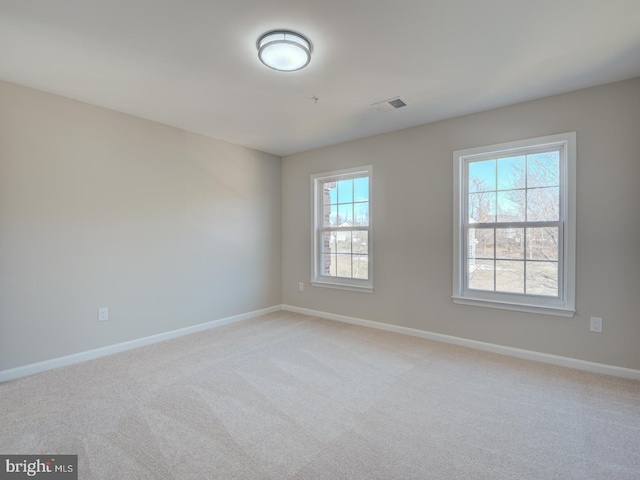 empty room with light carpet and plenty of natural light