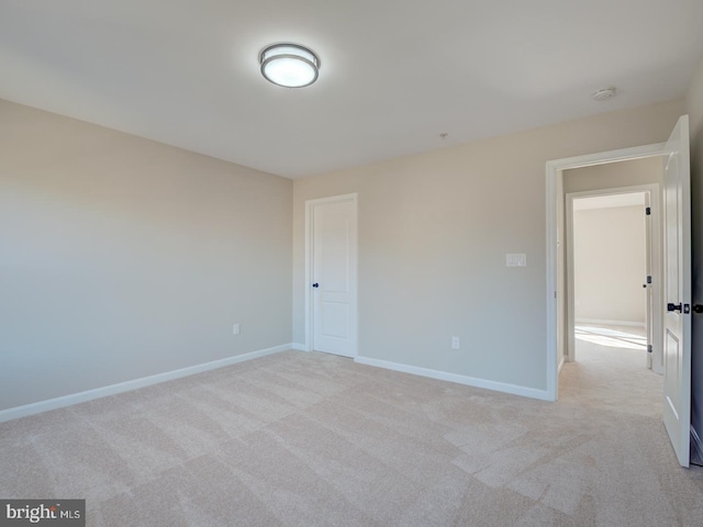 unfurnished room featuring light colored carpet