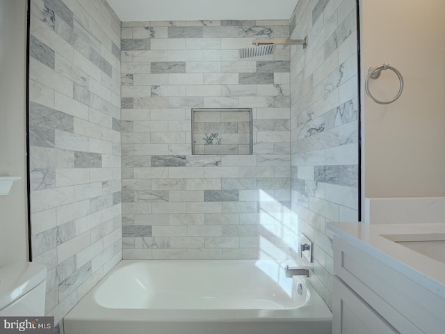 full bathroom featuring tiled shower / bath combo, toilet, and vanity