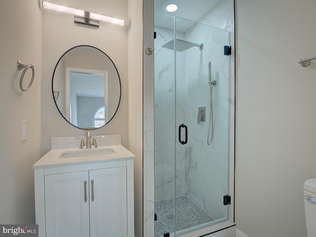 bathroom featuring walk in shower, vanity, and toilet