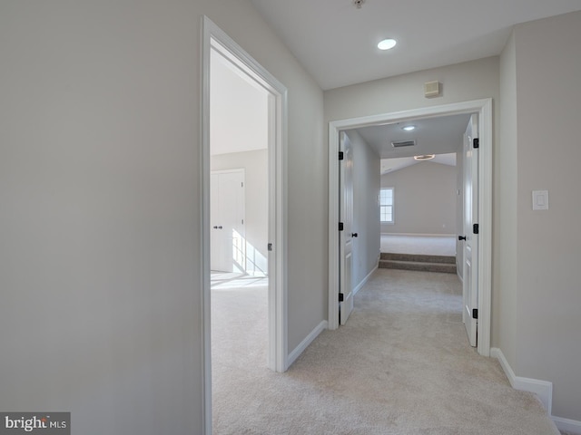 hall with light colored carpet