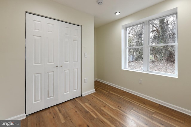 unfurnished bedroom featuring hardwood / wood-style floors and a closet