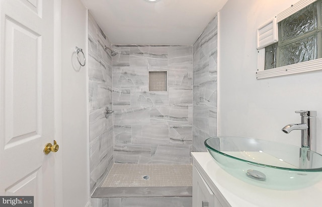 bathroom with vanity and tiled shower