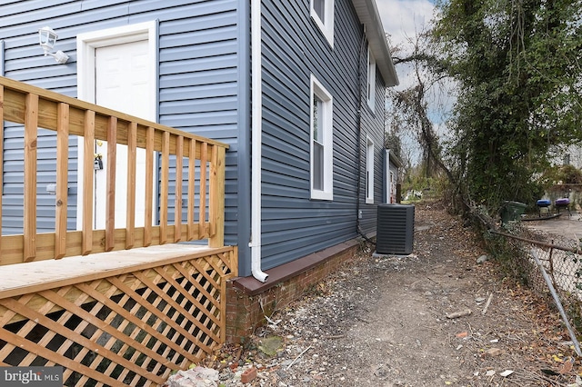 view of side of property featuring central AC unit and a deck