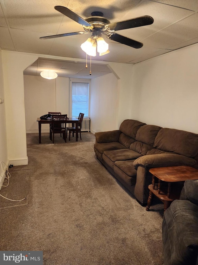 living room with carpet, ceiling fan, and radiator