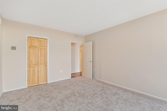 unfurnished bedroom featuring carpet and baseboards