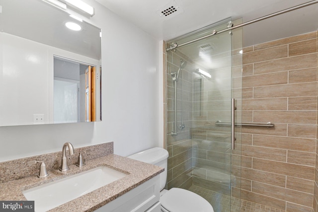 full bath featuring visible vents, toilet, a stall shower, and vanity