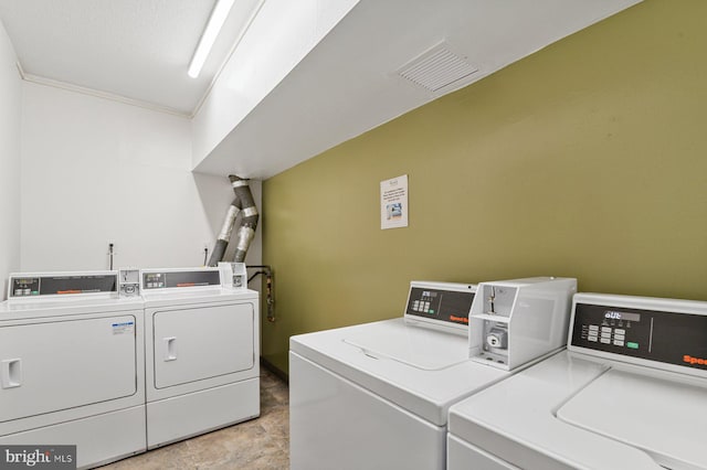 community laundry room with visible vents and washer and clothes dryer