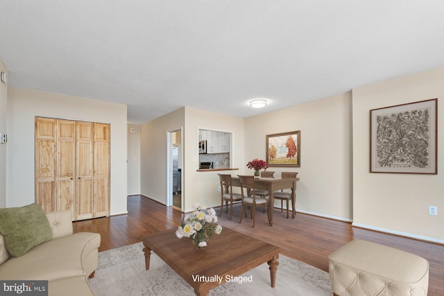 living area featuring dark wood-style floors and baseboards