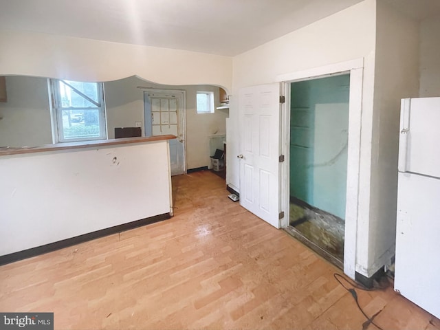 kitchen with light wood-type flooring and white refrigerator