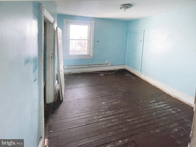 spare room featuring dark hardwood / wood-style flooring and a baseboard radiator