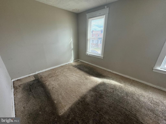 carpeted spare room featuring a textured ceiling