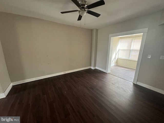 empty room with dark hardwood / wood-style flooring and ceiling fan