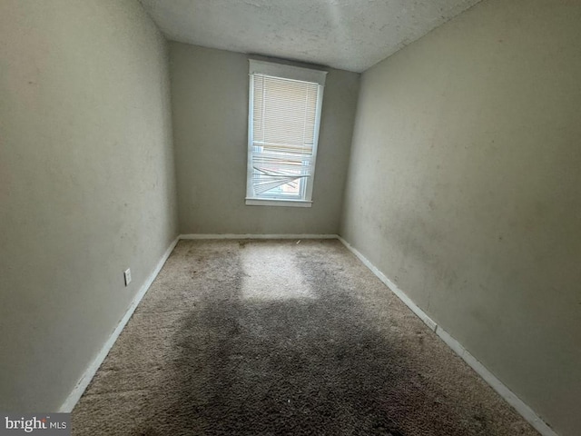 carpeted empty room featuring a textured ceiling