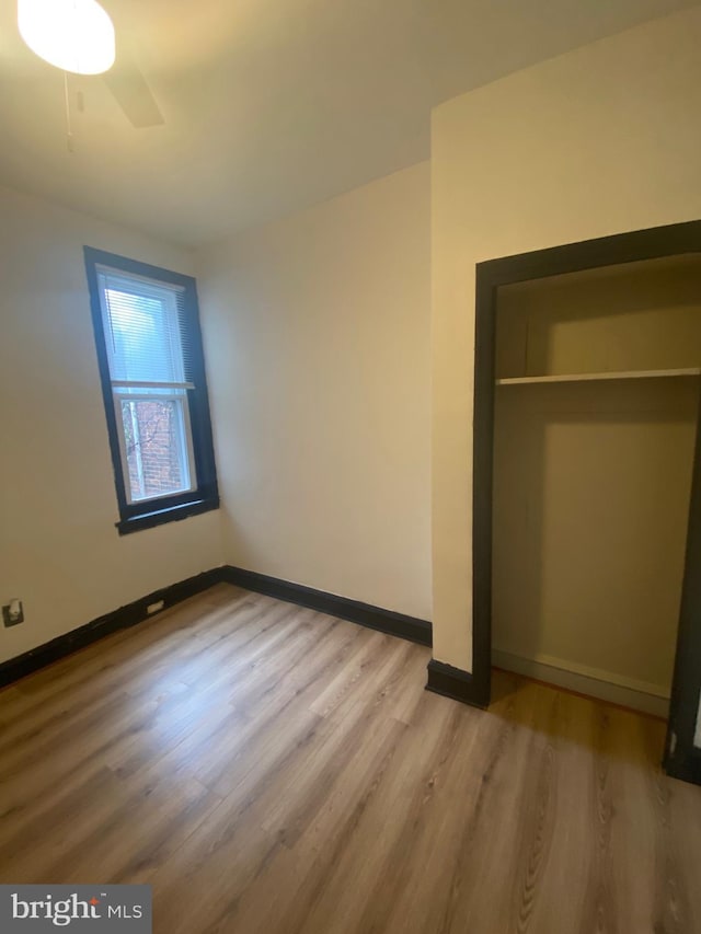 unfurnished bedroom with wood-type flooring and a closet