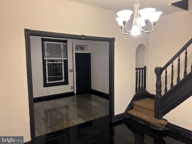 corridor featuring a textured ceiling and a chandelier