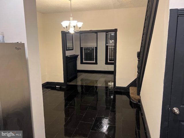 kitchen featuring dark tile patterned floors and a chandelier