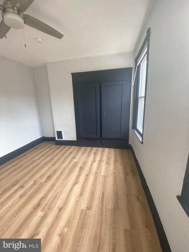 unfurnished bedroom featuring ceiling fan and light wood-type flooring