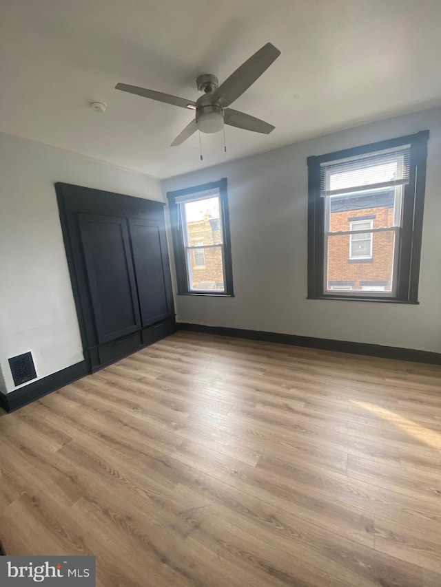 unfurnished bedroom with ceiling fan and light hardwood / wood-style floors