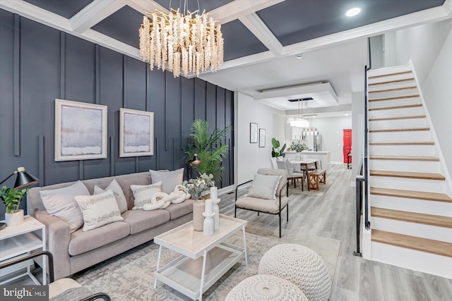 living room with coffered ceiling, a chandelier, beamed ceiling, and light hardwood / wood-style flooring