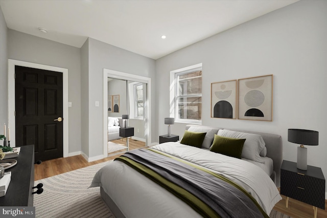 bedroom with light hardwood / wood-style floors and a closet