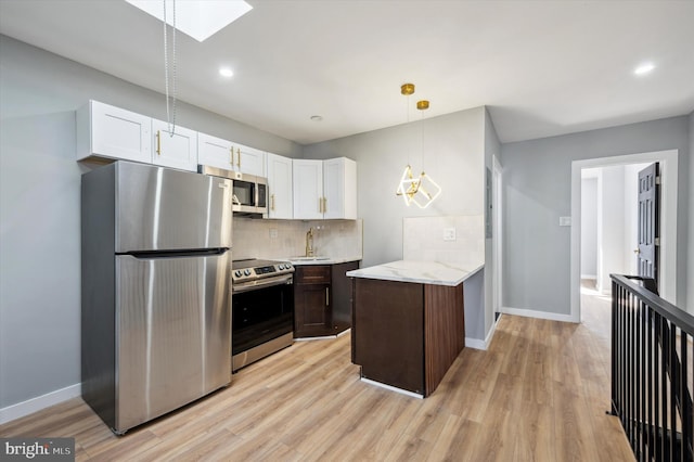 kitchen featuring backsplash, appliances with stainless steel finishes, dark brown cabinets, light hardwood / wood-style floors, and white cabinetry