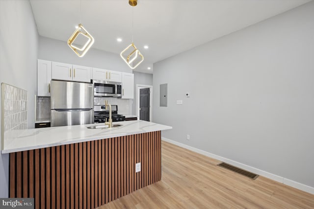 kitchen with kitchen peninsula, appliances with stainless steel finishes, light hardwood / wood-style flooring, white cabinets, and electric panel