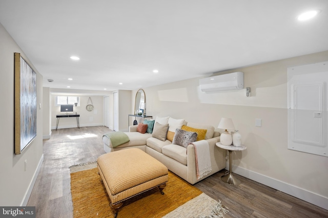 living room featuring wood-type flooring, electric panel, and a wall unit AC