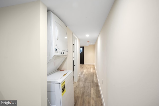 corridor featuring light hardwood / wood-style flooring and stacked washer and clothes dryer