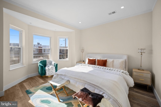 bedroom with crown molding and dark wood-type flooring