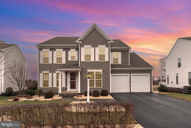 view of front of home featuring a garage and cooling unit