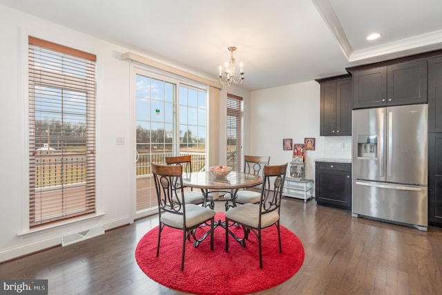 dining room with dark wood-type flooring and an inviting chandelier