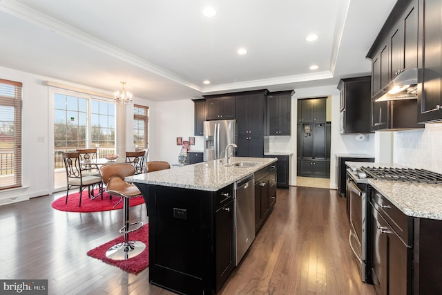 kitchen featuring an inviting chandelier, a center island with sink, decorative backsplash, dark hardwood / wood-style flooring, and stainless steel appliances