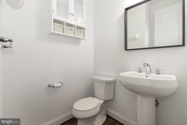 bathroom featuring hardwood / wood-style flooring and toilet