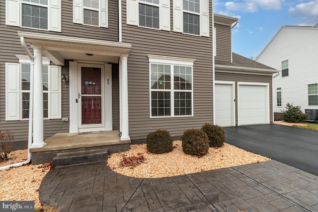 entrance to property featuring a garage and central AC