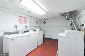 clothes washing area with washing machine and dryer