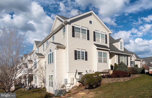 view of side of home featuring central AC and a yard