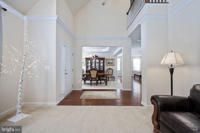 foyer featuring hardwood / wood-style floors, high vaulted ceiling, and ornamental molding