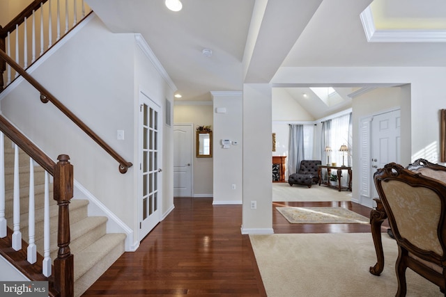 entryway with dark hardwood / wood-style floors, ornamental molding, french doors, and vaulted ceiling