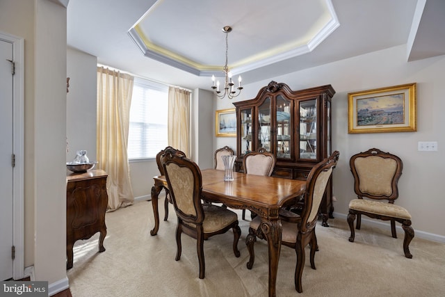 dining area featuring a chandelier, light colored carpet, and a tray ceiling