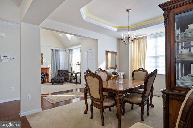 dining area featuring hardwood / wood-style floors, ornamental molding, vaulted ceiling, and a notable chandelier